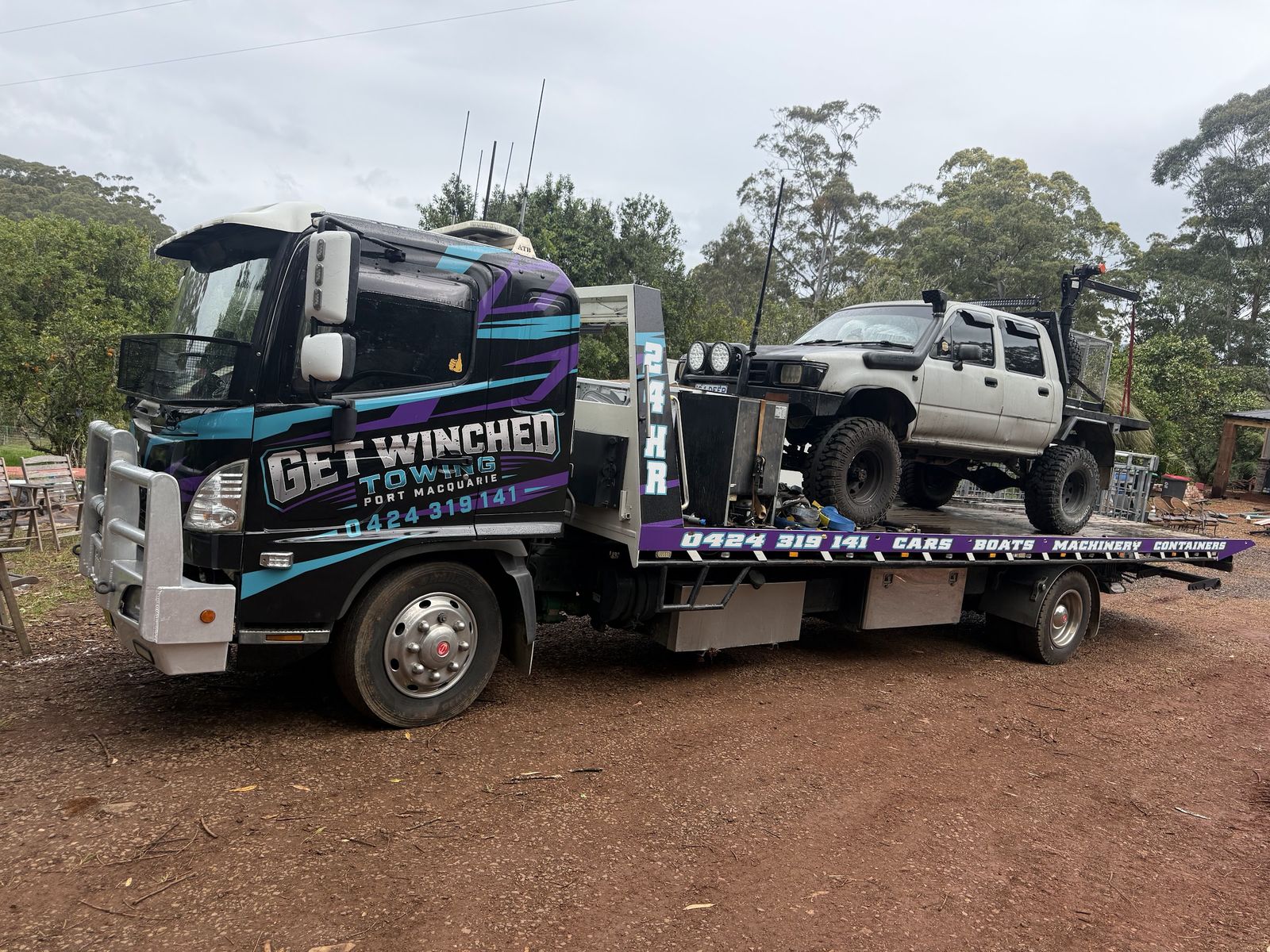 Lifted Hilux dual cab on the back of the Get Winched tilt tray on a red dirt track