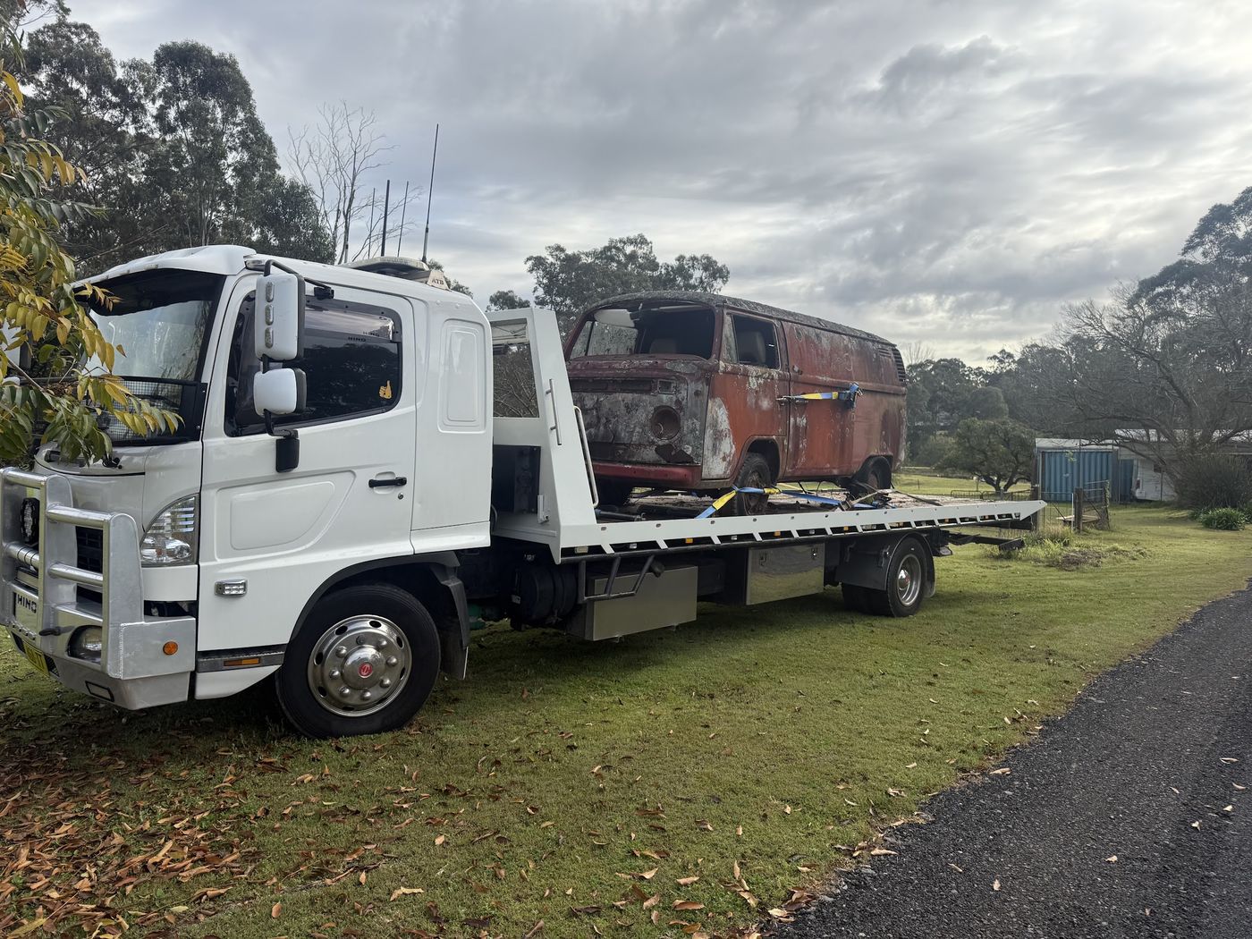 Rusty VW Kombi on the back of a tilt tray, being taken away